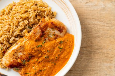 Kırmızı köri soslu ızgara tavuk bifteği ve pilav. Müslüman usulü.