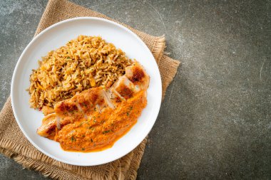 Kırmızı köri soslu ızgara tavuk bifteği ve pilav. Müslüman usulü.