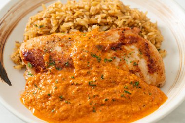 Kırmızı köri soslu ızgara tavuk bifteği ve pilav. Müslüman usulü.