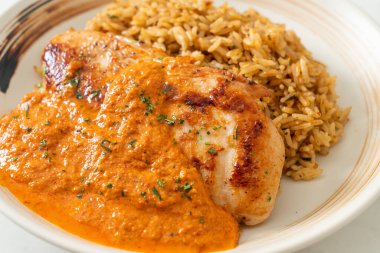 Kırmızı köri soslu ızgara tavuk bifteği ve pilav. Müslüman usulü.