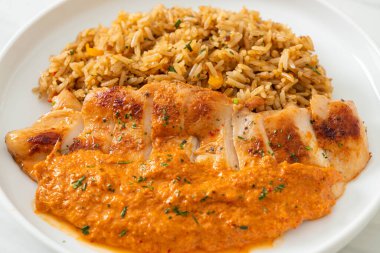 Kırmızı köri soslu ızgara tavuk bifteği ve pilav. Müslüman usulü.