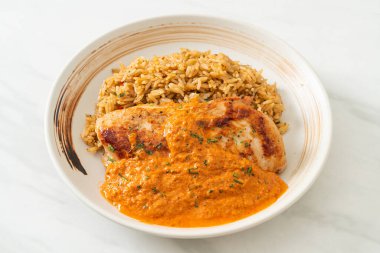 Kırmızı köri soslu ızgara tavuk bifteği ve pilav. Müslüman usulü.