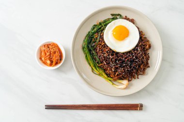 Ev yapımı kurutulmuş Kore baharatlı baharatlı siyah sos kızarmış yumurta ve kimchi ile hazır erişte.
