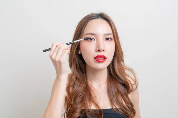 Stock image portrait beautiful Asian woman with makeup eye brush on white background