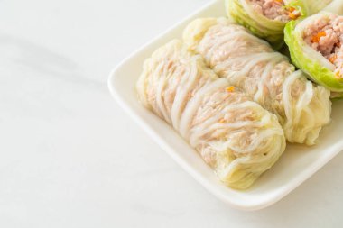 Çin lahanasına sarılı ev yapımı kıymalı domuz eti ya da haşlanmış lahana.