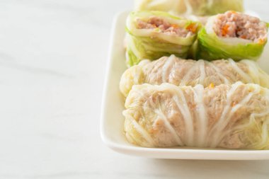 Çin lahanasına sarılı ev yapımı kıymalı domuz eti ya da haşlanmış lahana.