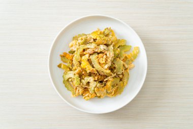 Kızarmış acı kabağı tabakta yumurta ile karıştır