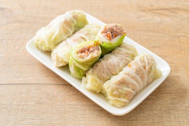 Çin lahanasına sarılı ev yapımı kıymalı domuz eti ya da haşlanmış lahana.