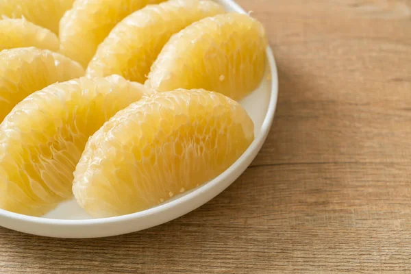 stock image Fresh peeled pomelo, grapefruit or shaddock on white plate