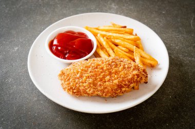 Kızarmış tavuk göğsü fileto biftek yanında patates kızartması ve ketçap.