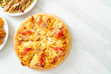 jambonlu ve yengeçli pizza veya Hawaii pizzası.