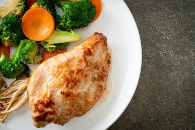 Beyaz tabakta sebzeli ızgara tavuk bifteği