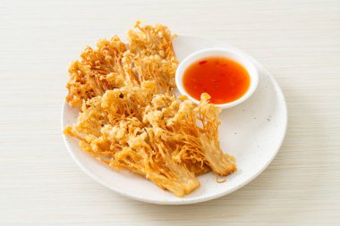 Kızarmış enoki mantarı ya da baharatlı soslu altın iğneli mantar - vejetaryen yemek tarzı.