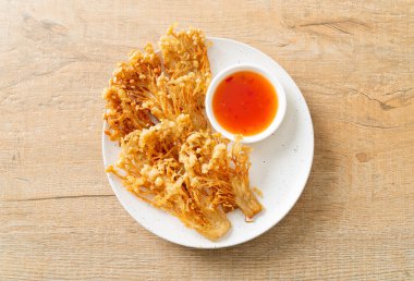 Kızarmış enoki mantarı ya da baharatlı soslu altın iğneli mantar - vejetaryen yemek tarzı.