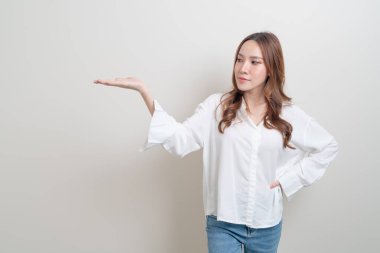 Güzel Asyalı kadın portresi beyaz arka planda el sallıyor ya da işaret ediyor.