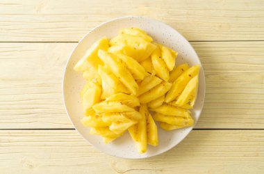 Beyaz tabakta dilimlenmiş taze ananas.