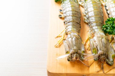 Tahtada limon olan taze peygamber devesi karidesi.