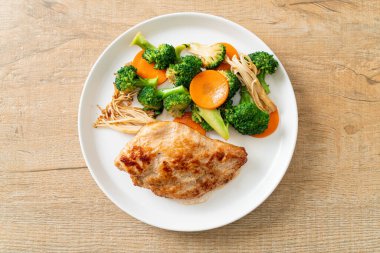 Beyaz tabakta sebzeli ızgara tavuk bifteği