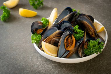 Limonlu bir kasede otlu taze midyeler.