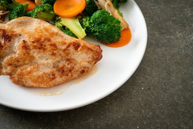 Beyaz tabakta sebzeli ızgara tavuk bifteği