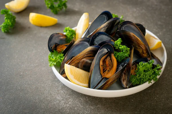 Limonlu bir kasede otlu taze midyeler.
