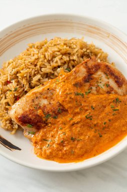 Kırmızı köri soslu ızgara tavuk bifteği ve pilav. Müslüman usulü.