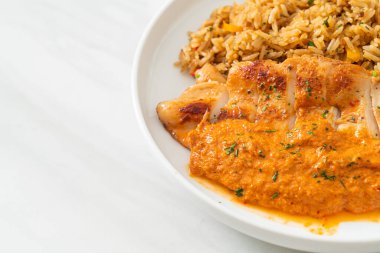 Kırmızı köri soslu ızgara tavuk bifteği ve pilav. Müslüman usulü.