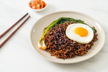 Ev yapımı kurutulmuş Kore baharatlı baharatlı siyah sos kızarmış yumurta ve kimchi ile hazır erişte.