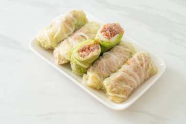 Çin lahanasına sarılı ev yapımı kıymalı domuz eti ya da haşlanmış lahana.