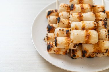 Izgara tüp şeklinde balık ezmeli kek ya da tabakta mürekkep balığı şişi.