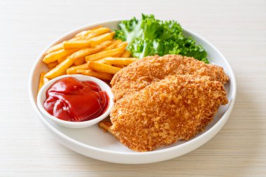 Kızarmış tavuk göğsü fileto biftek yanında patates kızartması ve ketçap.