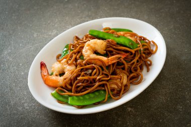 Kızarmış yakisoba eriştesi, yeşil bezelye ve karides, Asya usulü.