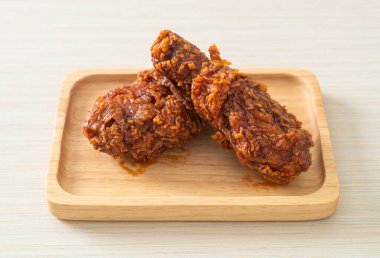 Tahta tabakta baharatlı Kore soslu kızarmış tavuk.