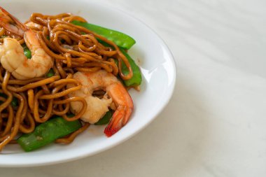 Kızarmış yakisoba eriştesi, yeşil bezelye ve karides, Asya usulü.