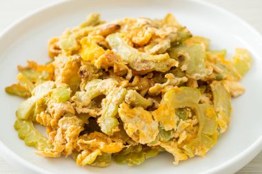 Kızarmış acı kabağı tabakta yumurta ile karıştır