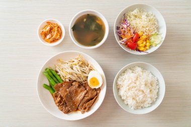 Susamlı teriyaki domuz kızartması, fasulye filizi, haşlanmış yumurta ve pirinç seti - Japon yemek tarzı.