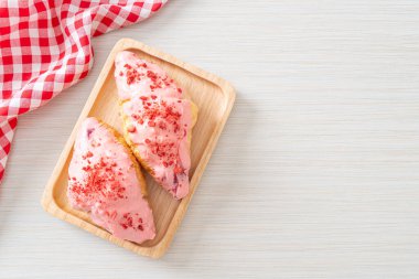 Tahta tabakta çilekli çikolata soslu kruvasan.