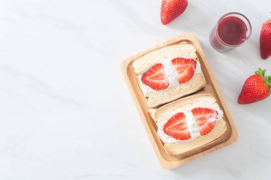 gözlemeli sandviç, çilekli taze krema, ahşap tabakta.