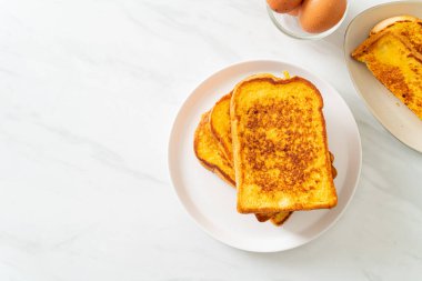 Kahvaltı için beyaz tabakta yumurtalı ekmek.