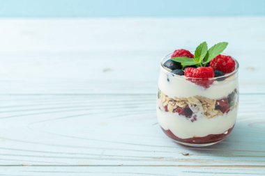 Ev yapımı ahududu ve yaban mersinli yoğurt ve granola. Sağlıklı yemek tarzı.