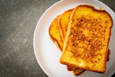 Kahvaltı için beyaz tabakta yumurtalı ekmek.