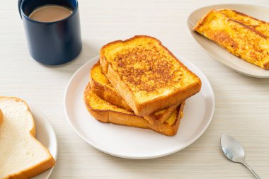 Kahvaltı için beyaz tabakta yumurtalı ekmek.