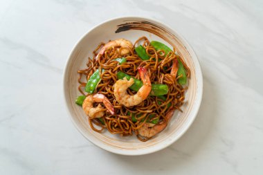 Kızarmış yakisoba eriştesi, yeşil bezelye ve karides, Asya usulü.