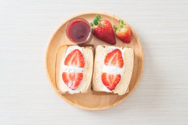 gözlemeli sandviç, çilekli taze krema, ahşap tabakta.