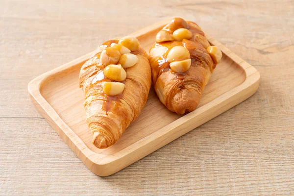 Croissant Mit Macadamia Und Karamell Auf Holzteller — Stockfoto