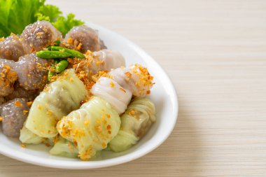 Şeffaf toplara Saku Sai Moo ya da Buharlı Tapioca Köfte Topları ve (Kow Griep Pag Mor) Domuz Buharlı Pirinç Paketleri ya da Haşlanmış Pirinç Kabuklu Mantı denir.