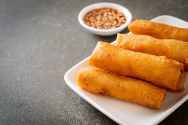 Kızarmış yumurta rulosu ve beyaz tabakta sos.