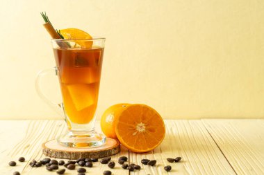 Bir bardak buzlu americano sade kahve ve biberiye ve tarçınla süslenmiş portakal ve limon suyu.