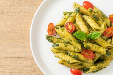Pesto soslu ve domatesli makarna. Vejetaryen ve vejetaryen yemek tarzı.