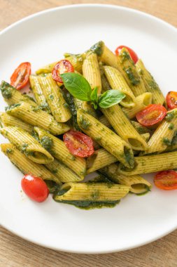 Pesto soslu ve domatesli makarna. Vejetaryen ve vejetaryen yemek tarzı.